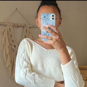 An off-white cropped shoulder sweater with knit detailing on both sleeves